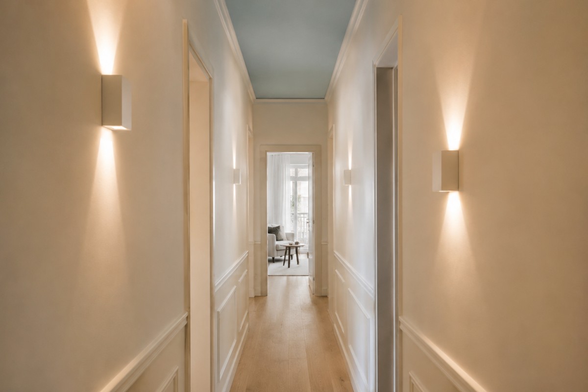 Corridoio luminoso con soffitto azzurro polvere e applique discrete