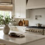 Cucina bianca luminosa aggiornata con acciaio spazzolato, legno caldo e tessili naturali