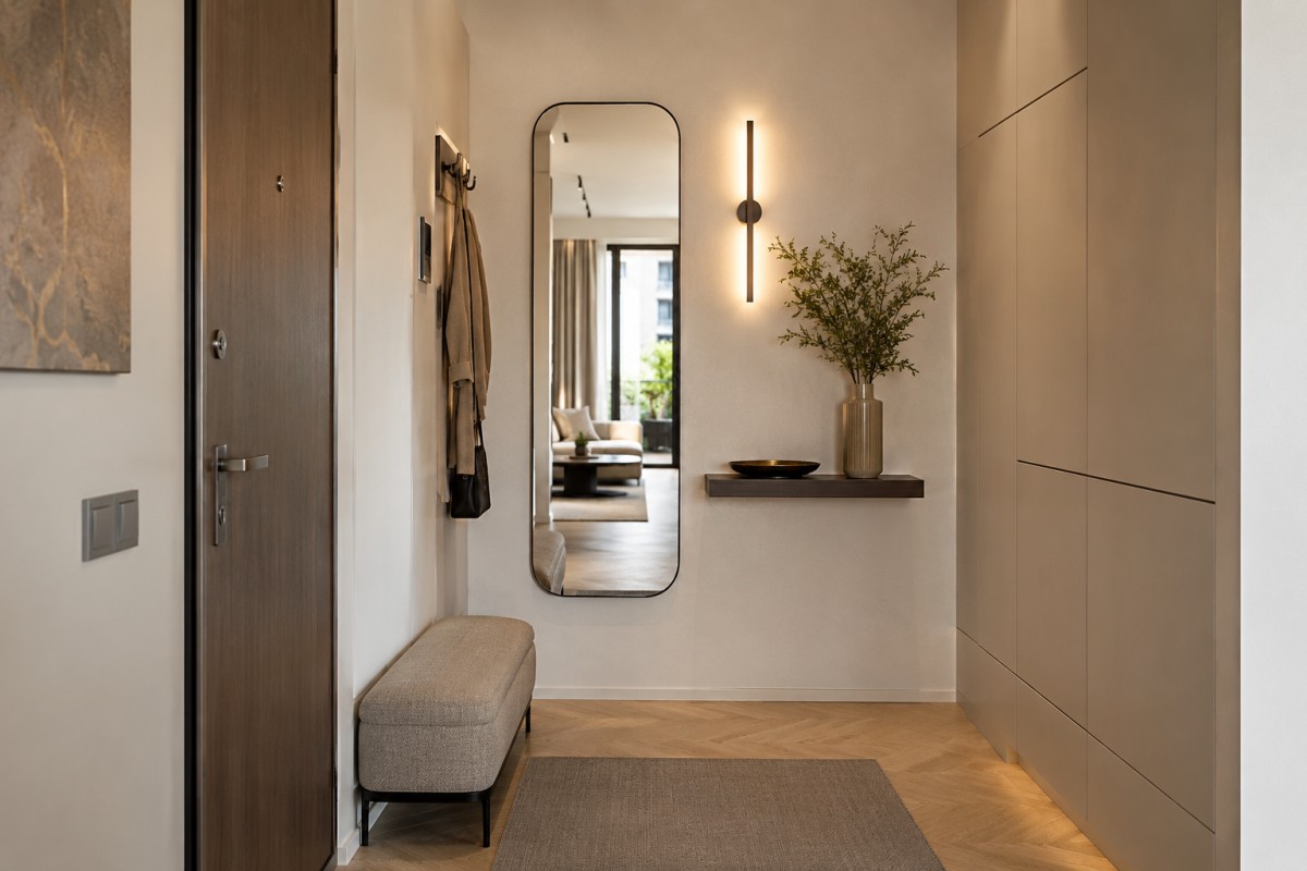 Ingresso stretto arredato con specchio alto mensola sottile e luce calda