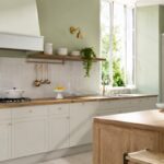 Cucina verde pistacchio con legno caldo e luce naturale