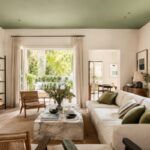 Soggiorno luminoso con soffitto verde salvia e arredi naturali