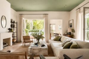 Soggiorno luminoso con soffitto verde salvia e arredi naturali