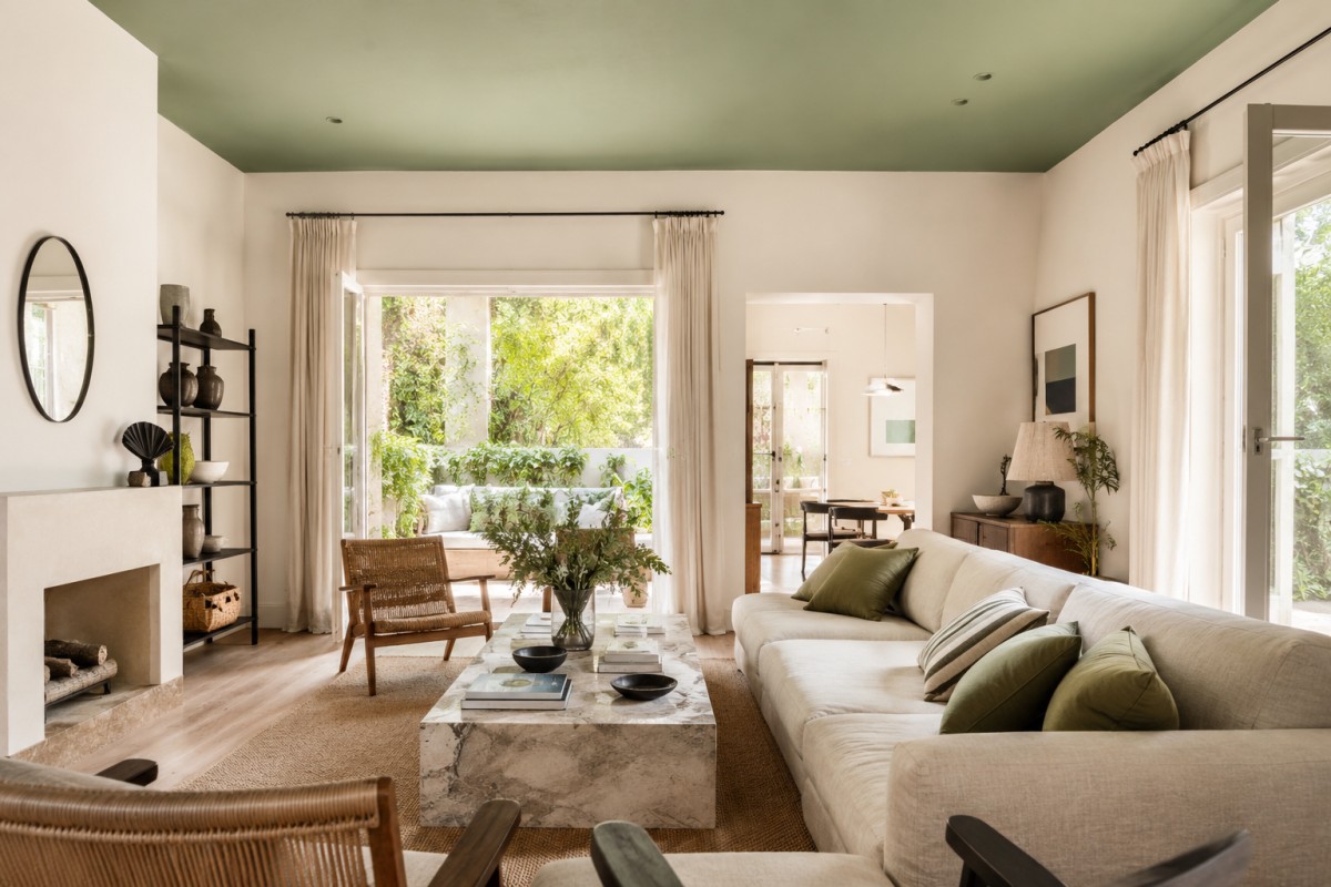 Soggiorno luminoso con soffitto verde salvia e arredi naturali