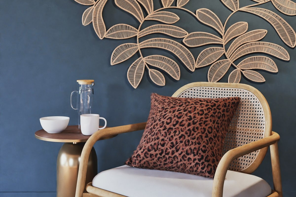 Decorazione Maisons du Monde KAYA in juta su parete blu con poltrona