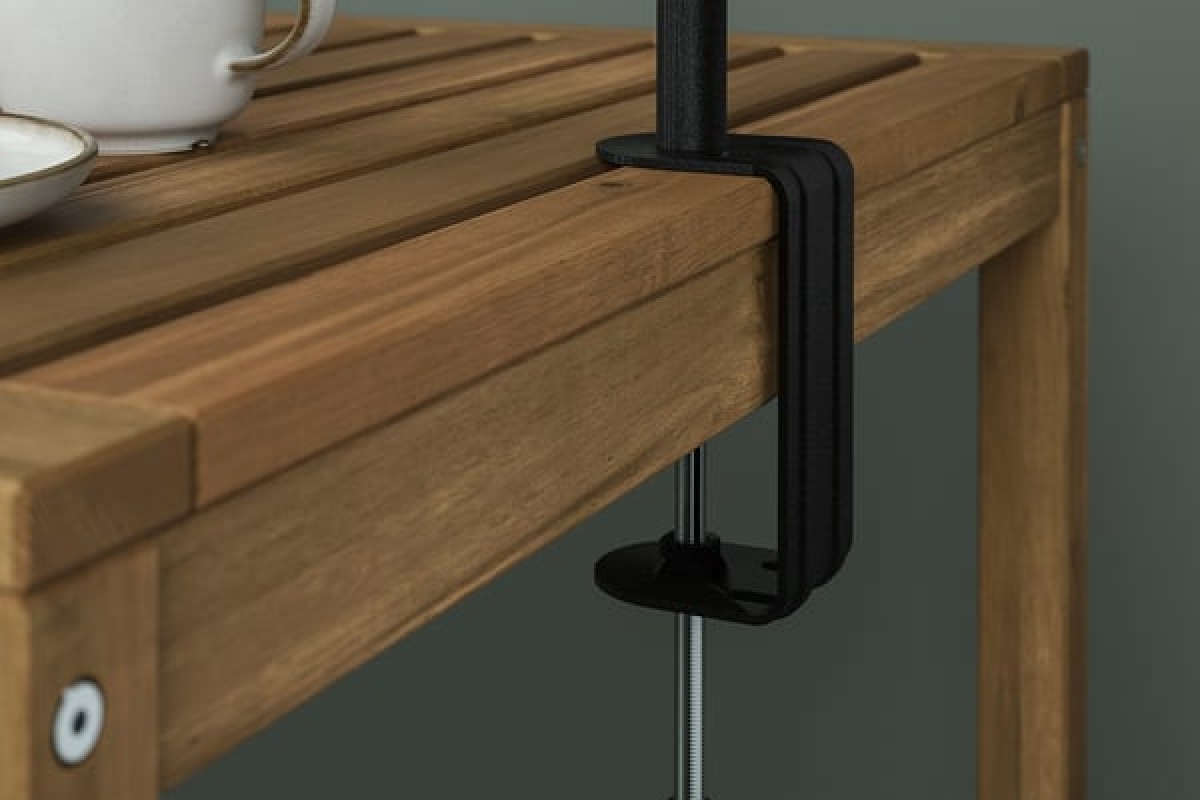 Dettaglio del morsetto IKEA HELGEÖ fissato a un tavolo in legno