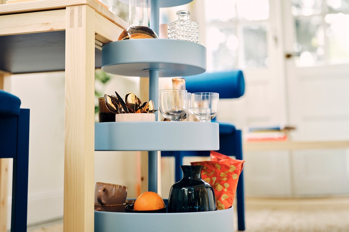 Dettaglio del carrello IKEA PS 2026 con ripiani blu e oggetti ordinati
