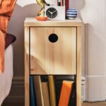 Comodino IKEA PS 2026 in pino accanto al letto con libri e piccoli oggetti