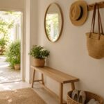 Ingresso estivo ordinato con panca sottile ganci e specchio rotondo