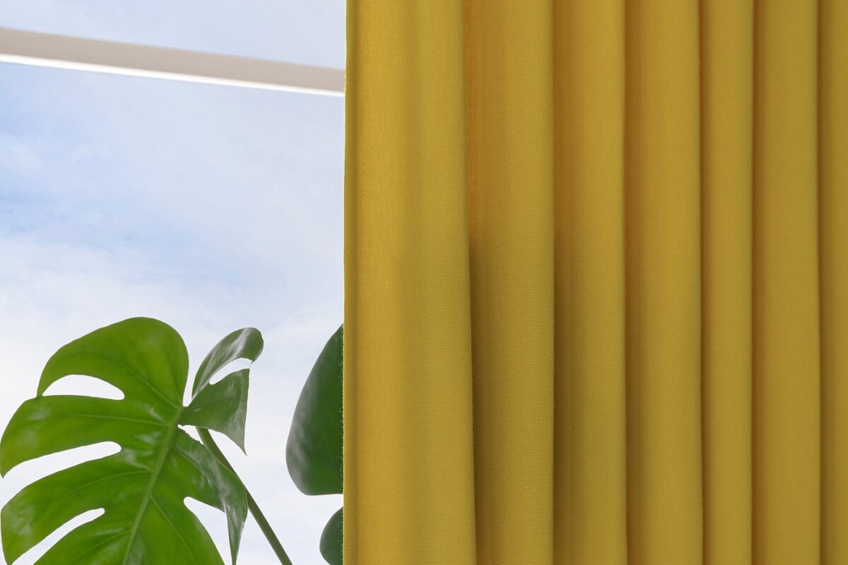 Dettaglio del tessuto giallo delle tende IKEA GINSTMOTT vicino a una finestra