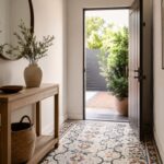Ingresso contemporaneo con pavimento a mosaico decorativo e console in legno