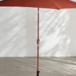 Ombrellone Selaya Maisons du Monde color terracotta aperto su terrazzo luminoso