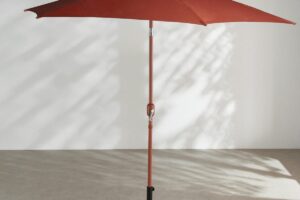 Ombrellone Selaya Maisons du Monde color terracotta aperto su terrazzo luminoso