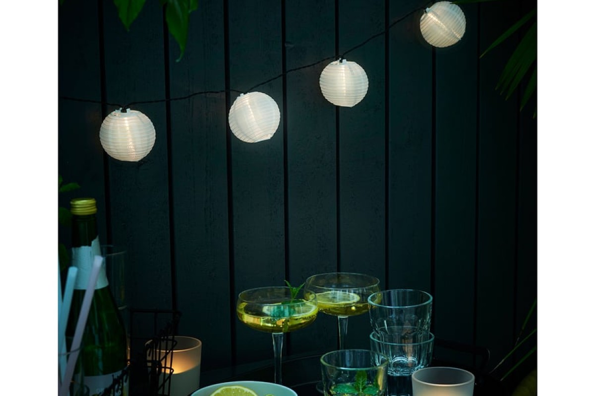 Luci solari IKEA SOLARVET accese sopra un tavolino serale