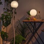 Lampada solare IKEA SOLVINDEN su balcone estivo con tavolino e piante