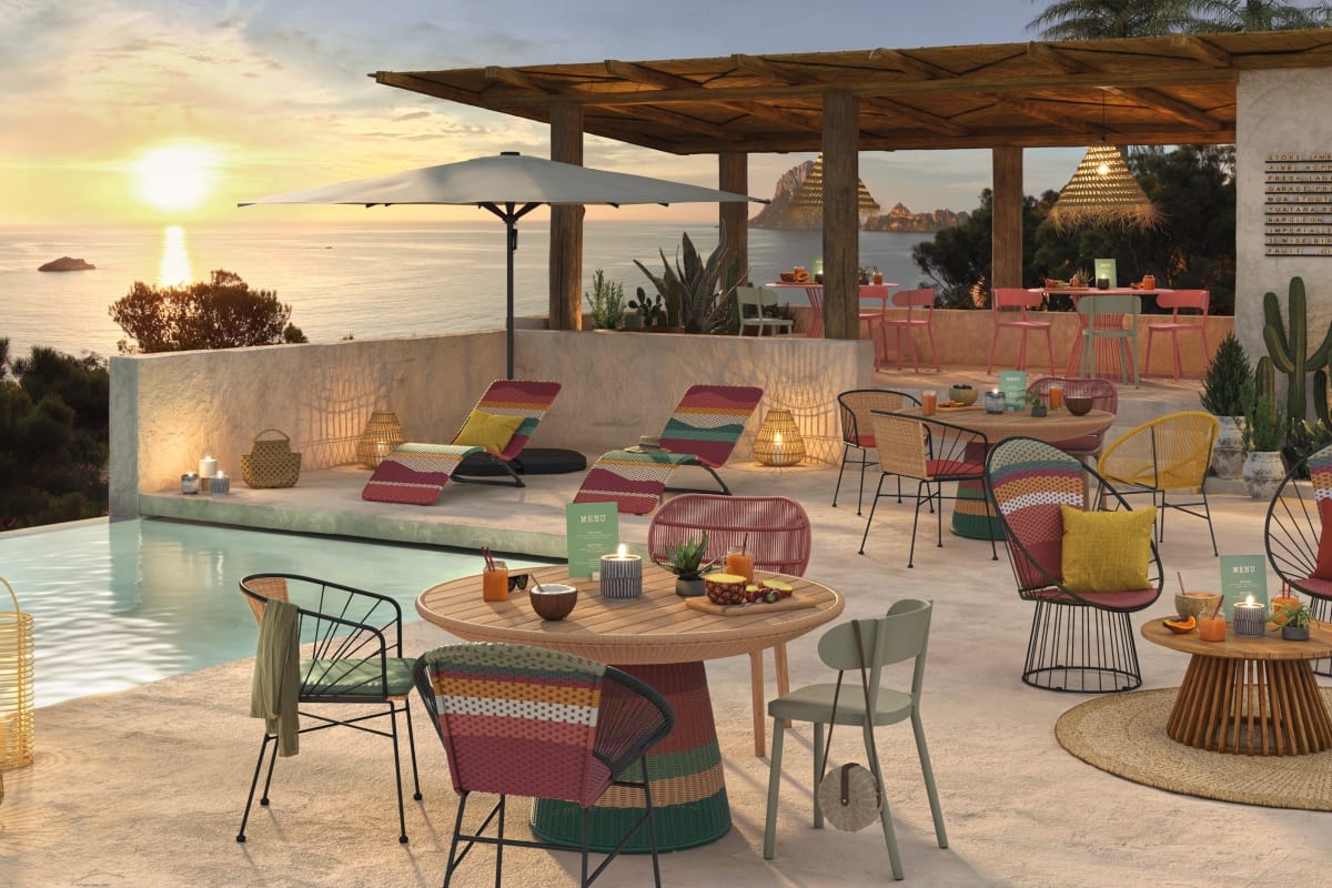 Tavolino Baya su terrazza estiva con sedute colorate e atmosfera conviviale