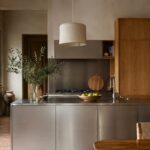 Cucina calda con isola in acciaio spazzolato e mobili in rovere