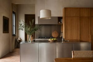 Cucina calda con isola in acciaio spazzolato e mobili in rovere