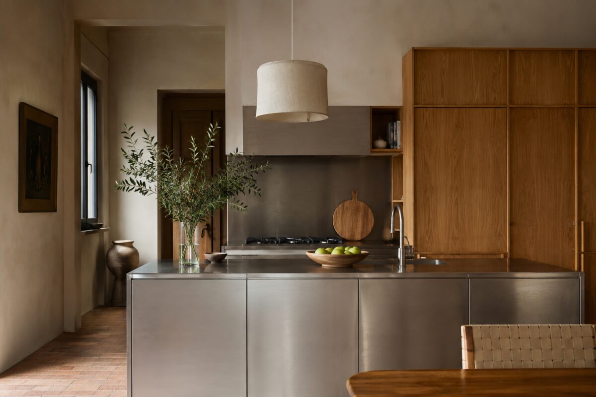 Cucina calda con isola in acciaio spazzolato e mobili in rovere