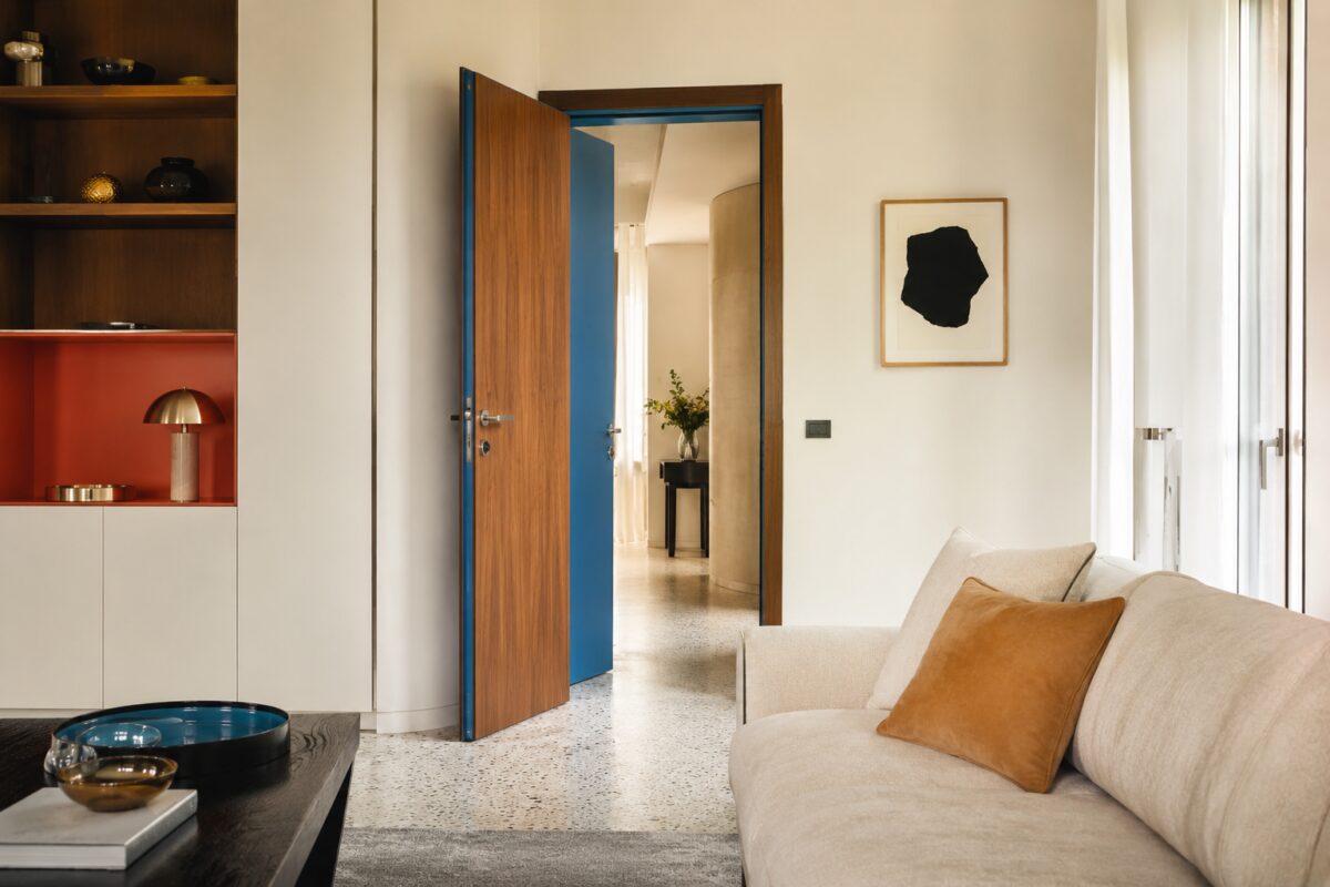 Soggiorno neutro con porta aperta dipinta di blu sul lato nascosto