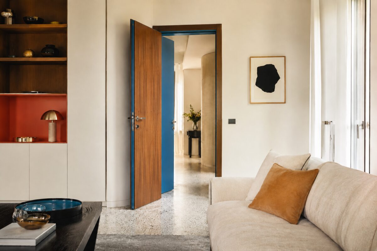 Soggiorno neutro con porta aperta dipinta di blu sul lato nascosto