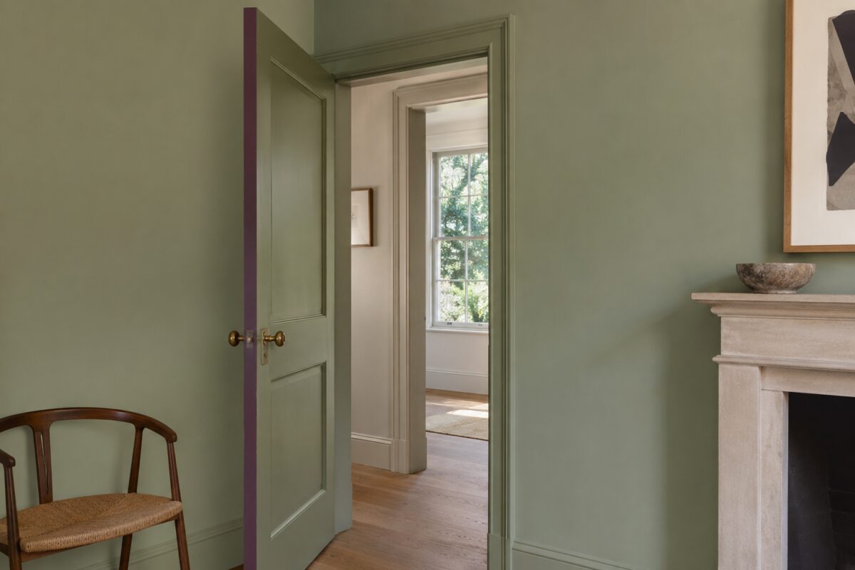 Spessore di una porta color prugna in una stanza verde minerale