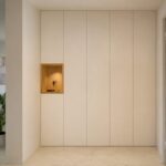 Ingresso con guardaroba a filo muro bianco e nicchia in legno