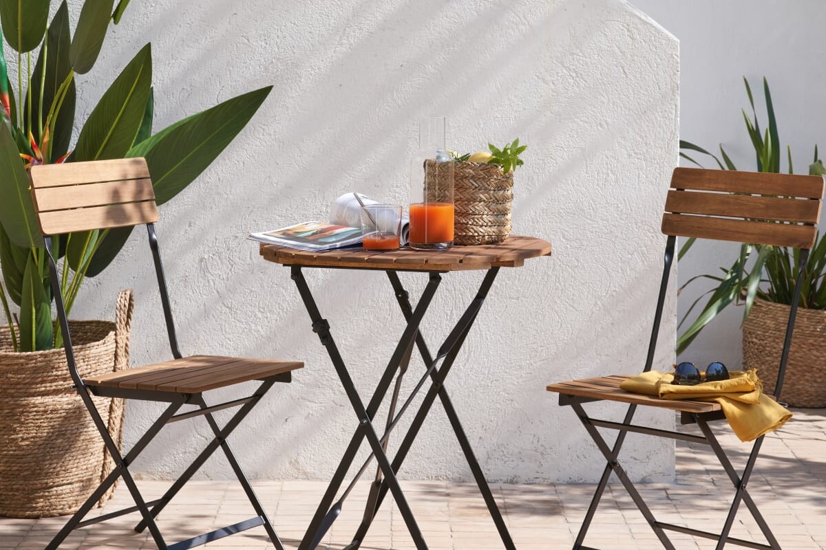 Tavolo CALATHEA Maisons du Monde in acacia su piccolo balcone estivo