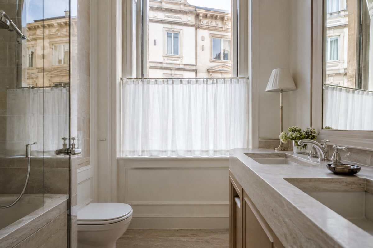 Tenda corta bianca su una finestra del bagno