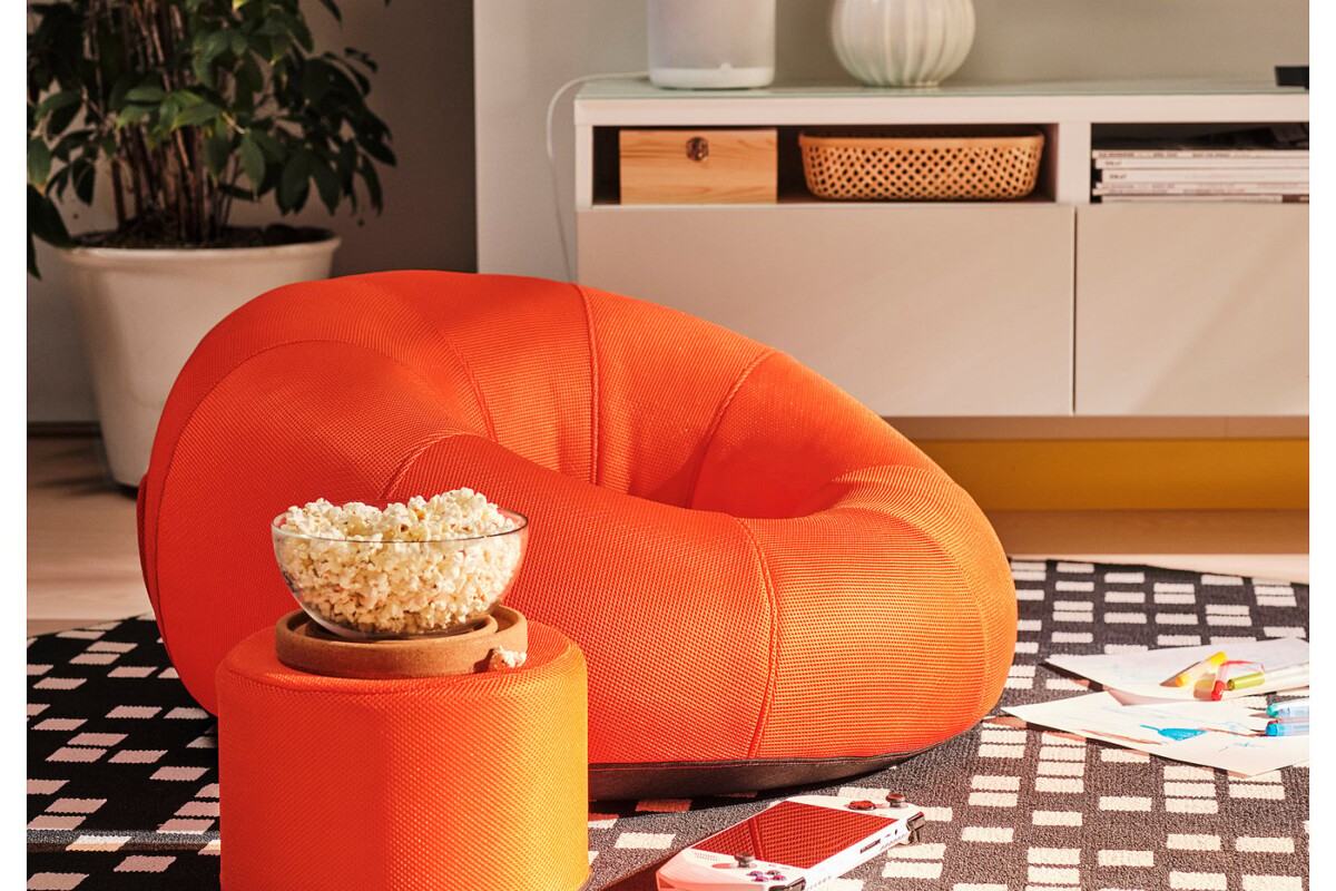 Poltrona gonfiabile IKEA BRÄNNBOLL arancione accanto alla zona televisore