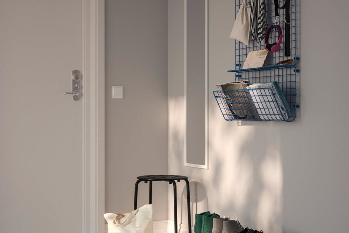 Sistema blu IKEA con griglia e scarpiera in un ingresso luminoso