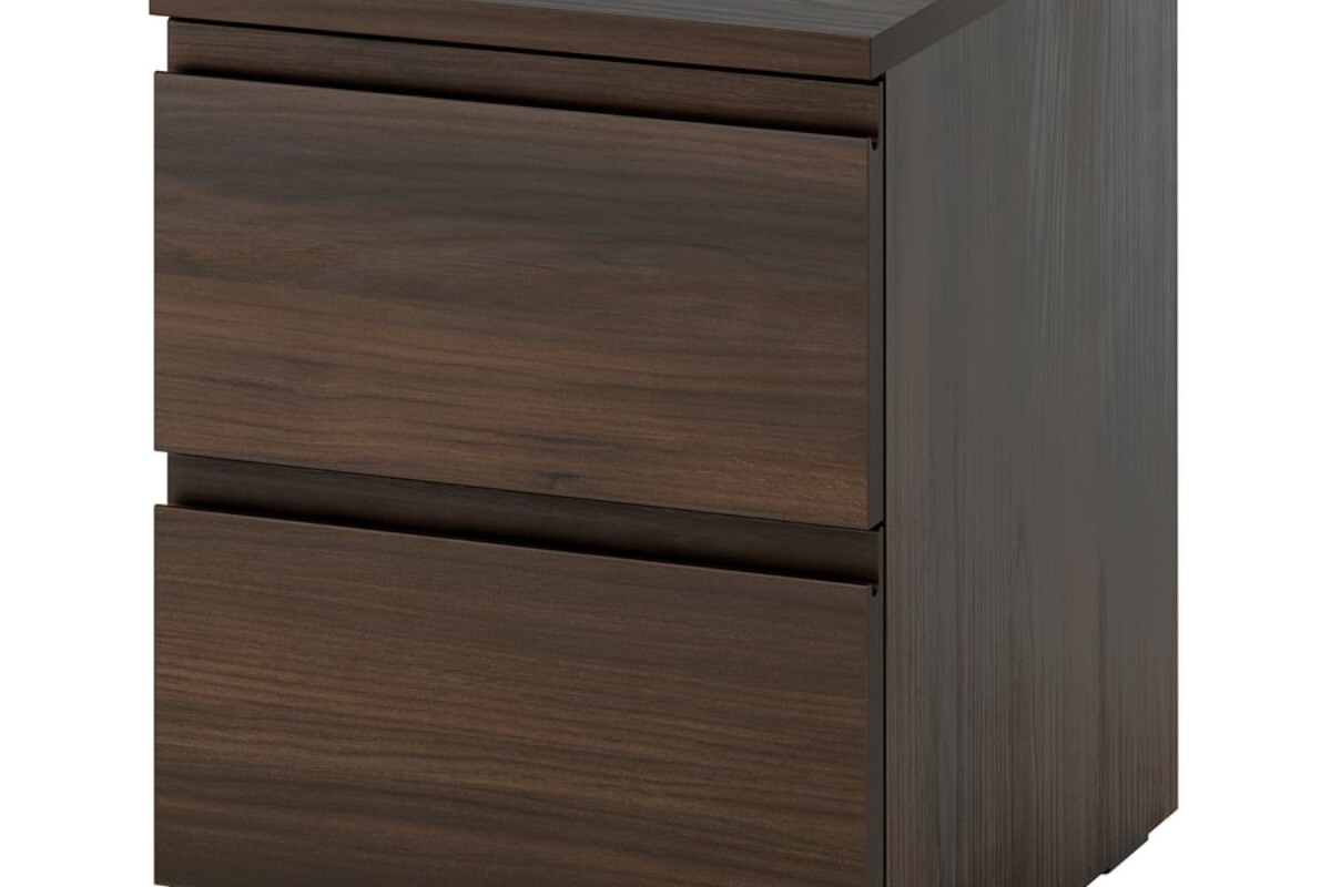 Due cassetti e legno scuro rendono il comodino più elegante senza appesantire la camera