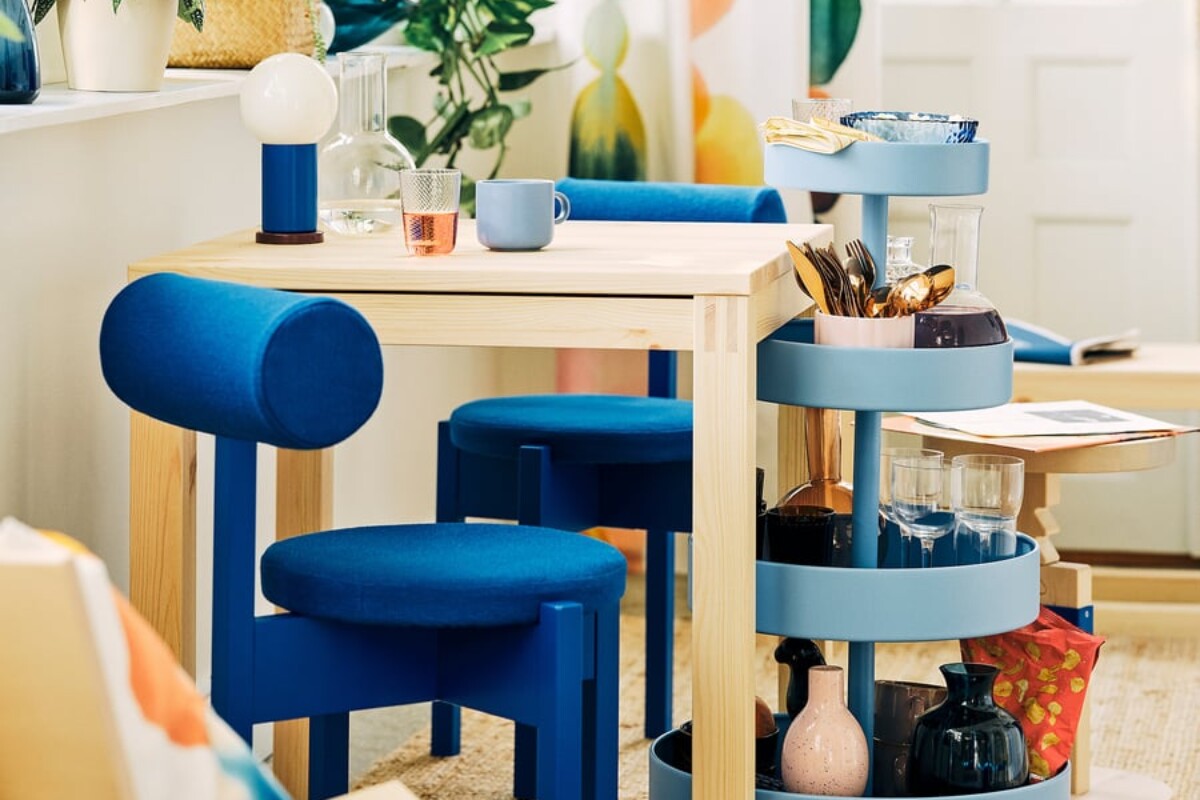 Cucina luminosa con sedie blu IKEA PS 2026 e tavolo in legno