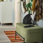 Panca contenitore IKEA VALTORP verde nell’ingresso con borsa e giacche