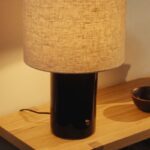 Lampada IKEA HALGATT accesa su una mensola in legno