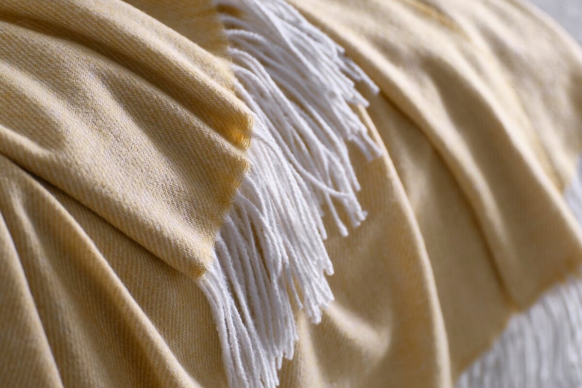 Dettaglio del plaid IKEA HOLMVI beige giallo con texture morbida e frange chiare