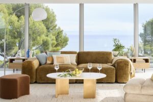 Divano senape Maisons du Monde in un soggiorno luminoso con arredi neutri