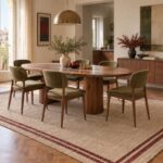 Sala da pranzo con tavolo ovale e sedie interamente appoggiate su un grande tappeto