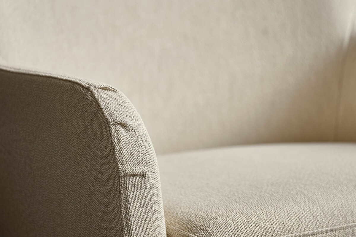 Dettaglio della poltrona FAGERBACKEN con schienale alto e rivestimento beige