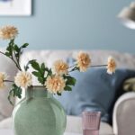 Vaso IKEA verde chiaro in gres con fiori bianchi su un tavolino in soggiorno