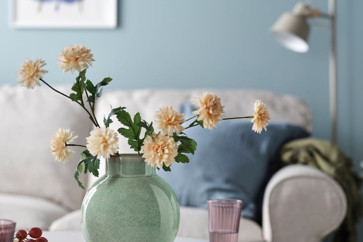 Vaso IKEA verde chiaro in gres con fiori bianchi su un tavolino in soggiorno