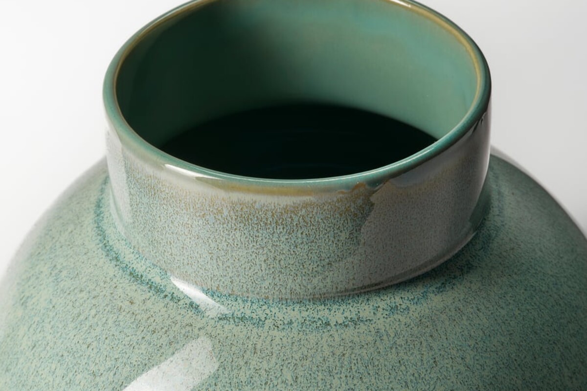 Vaso in gres verde chiaro usato come elemento decorativo su un mobile