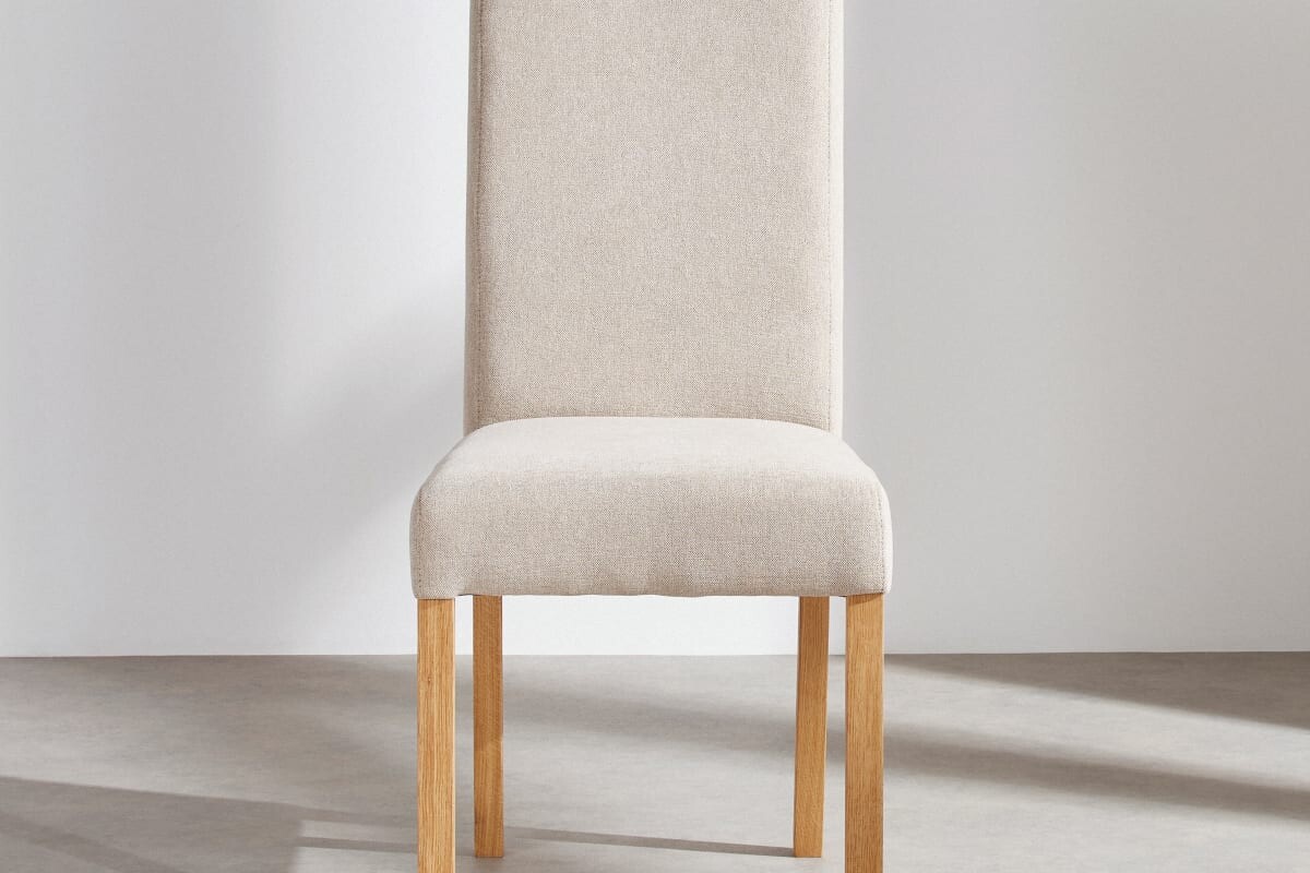 Dettaglio della sedia in tessuto beige e legno massello