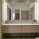 Bagno piccolo con grande specchio sopra un mobile lavabo sospeso
