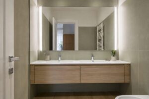 Bagno piccolo con grande specchio sopra un mobile lavabo sospeso