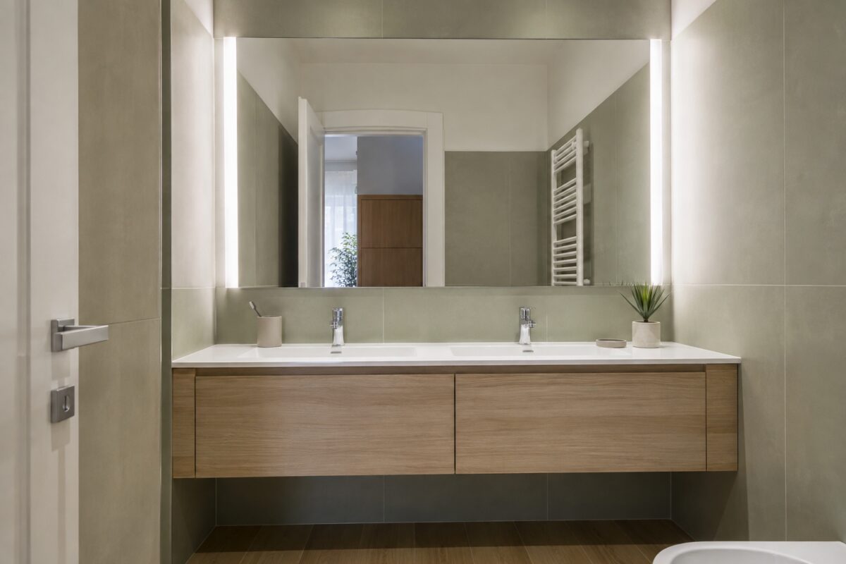 Bagno piccolo con grande specchio sopra un mobile lavabo sospeso