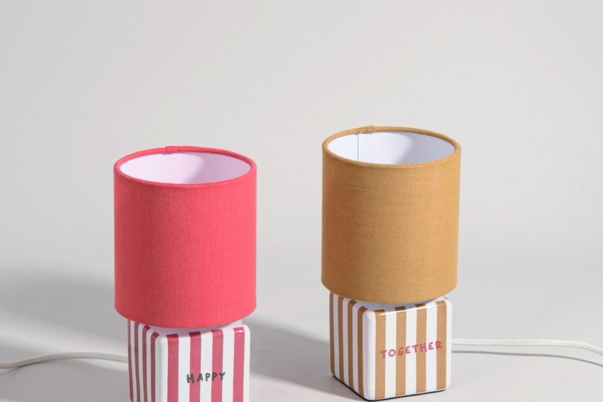 Dettaglio delle lampade Fanusa con righe colorate e paralumi in tessuto crema