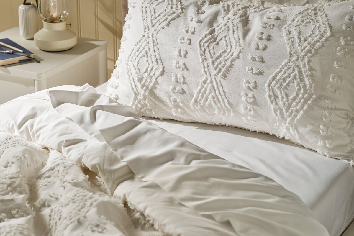 Trapunta SVÄMNIL IKEA su un letto bianco in una camera luminosa