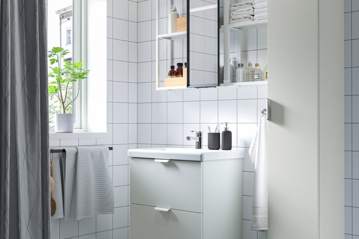 Mobile lavabo ENHET con specchio e colonna alta in un bagno luminoso