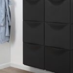 Moduli neri IKEA TRONES montati sulla parete di un ingresso luminoso