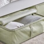 Custodia IKEA HEMMAFIXARE floreale aperta sotto un letto